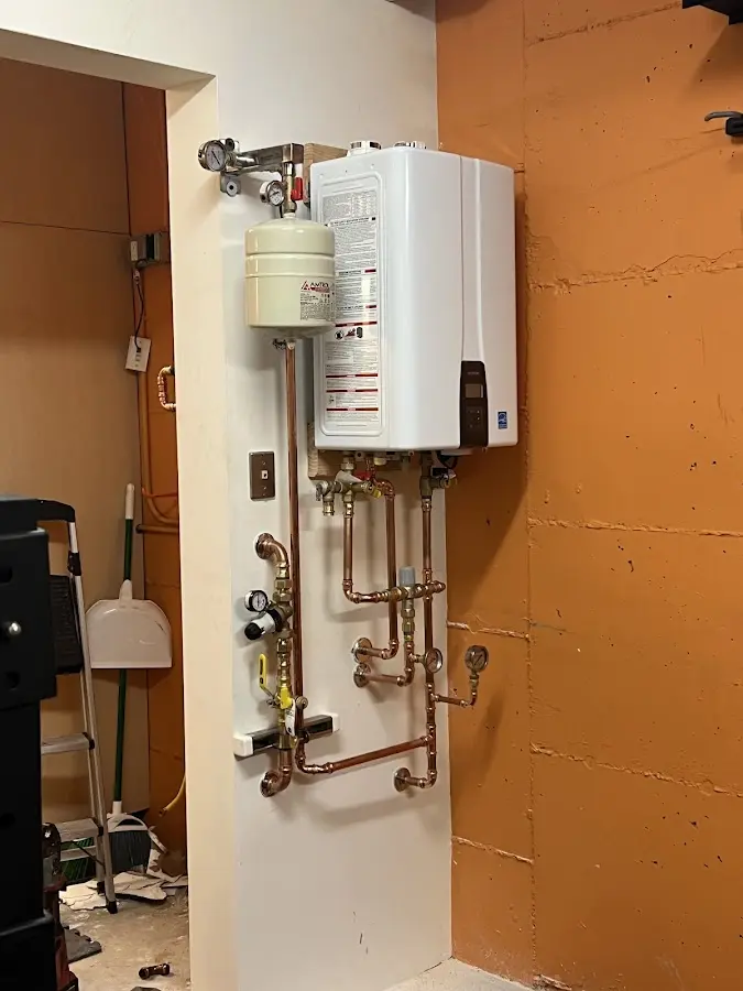 Plumbing technician inspecting water heater connections in Kenner